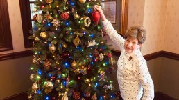 woman decorating a Christmas tree