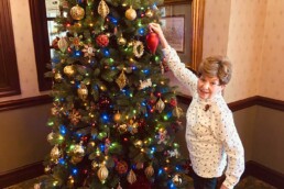 woman decorating a Christmas tree